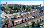 Karlstad i september 1965. Klockan r 10.45 och Norgepilen lmnar stationen med Ra 4 (988) som dragkraft. Destinationen r Oslo med ankomsttid 13.50. I frgrunden vxlar Ub 716.