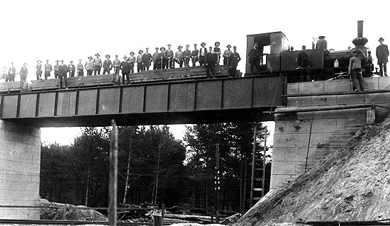 VSBJ nybyggda viadukt över SJ linjen i Skänninge 1913. För banbygget inhyrt SRJ lok 33 med ett arbetståg har stannat på viadukten för att fotografen ska kunna föreviga händelsen.
