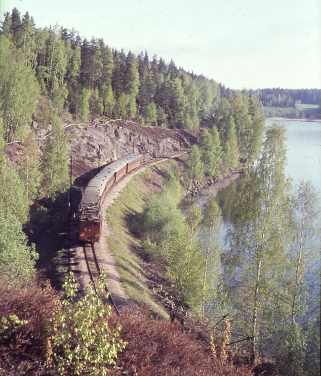 Nordmark - Klarlvens Jrnvgar, NKlJ, juni 1964. Persontg nummer 7, med ett AEG-lok som dragkraft, passerar Syrsjn