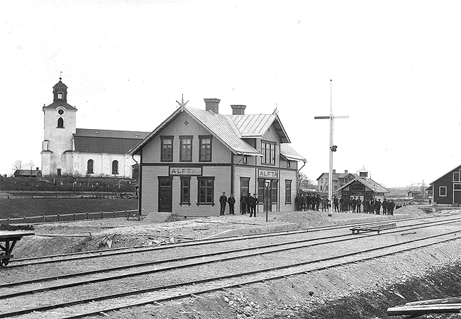 Dala Hlsinglands Jrnvg, DHdJ, Alfta station 1899. Den nybyggda bangrden med stationshus. Personal och en del av rallarna poserar infr fotografen