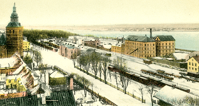 Bilden kommer från ett gammalt handcolorerat vykort 1906. Den visar en del av stationsområdet i Kristianstad.