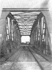 Bron över Ätran strax före ankomsten till Ätrans station. Stationshuset skymtar bortanför bron. Foto: Svenska Järnvägsföreningens minnesskrift 1876-1926..