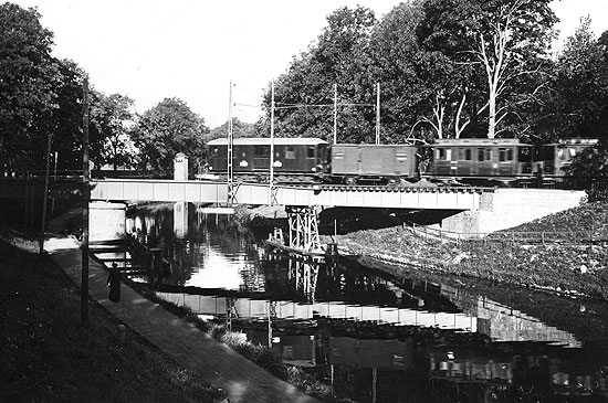 Ellok nummer 4 med persontåg har just lämnat Motala station och passerar över Göta Kanal på sin färd mot Fornåsa