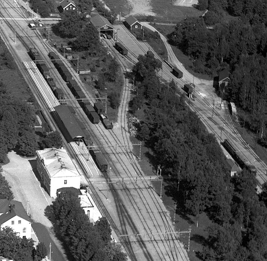 Flygfoto över en del av järnvägsområdet i Motala 1932. Till vänster Statens Järnvägar med stationshus.